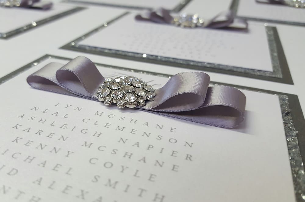 Wedding Business Dollybird Stationery Are Living The Dream At Storage Vault Work Space - close up of invite with silver glitter brooch