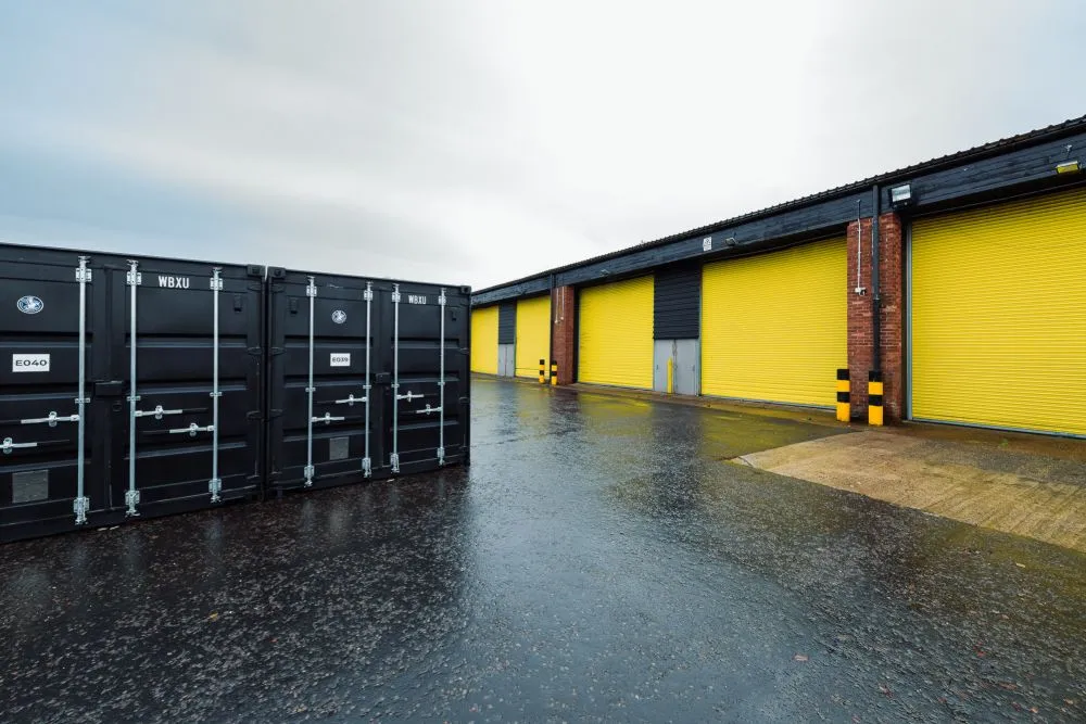 Drive-up storage containers next to yellow industrial units in Coatbridge