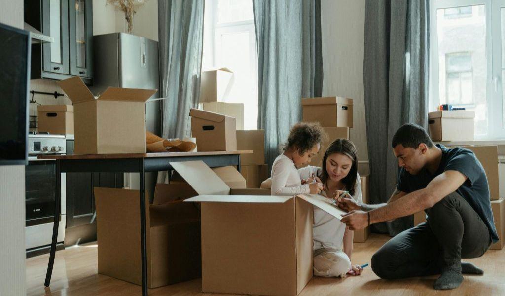 Family preparing for furniture storage with moving boxes in their home