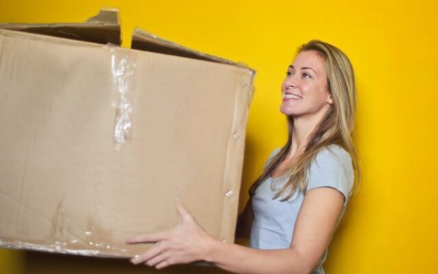 Woman carrying a box for moving house storage